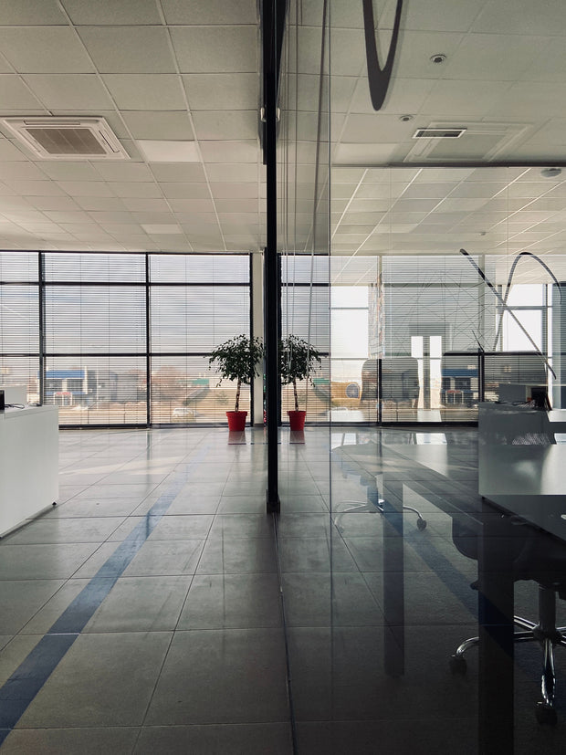 Helles modernes Büro mit Glaswänden, großen Fenstern und Pflanzen