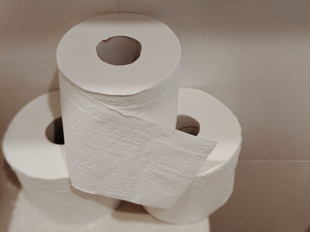 Ordentlich gestapelte weiße Toilettenpapierrollen